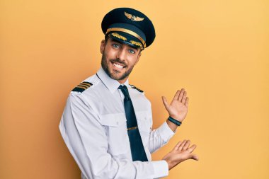 Uçak pilotu üniforması giyen yakışıklı İspanyol adam gülümseyerek doğal bir şekilde içeri girmeye çalışıyor. 