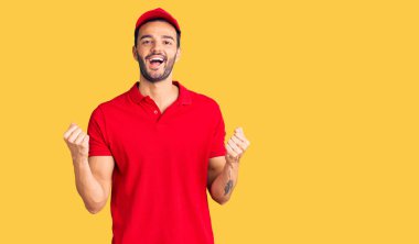 Yakışıklı İspanyol kurye üniforması giyen genç adam gururla bağırıyor, zaferi kutluyor ve başarıyı kollarını kaldırarak kutluyor. 