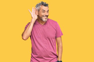 Orta yaşlı, gri saçlı, günlük kıyafetler giyen, ağzı kulaklarında gülümseyen, dedikoduları ve dedikoduları dinleyen bir adam. Sağırlık kavramı. 