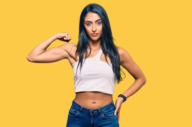 Güzel İspanyol kadın gündelik kıyafetler giyiyor güçlü biri kol kası gösteriyor, kendinden emin ve gururlu. 