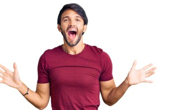 Yakışıklı İspanyol bir adam sıradan kıyafetler giyip çılgınlığı kutluyor ve başarıya hayret ediyor kolları açık ve gözleri açık heyecanla bağırıyor. Kazanan konsept 