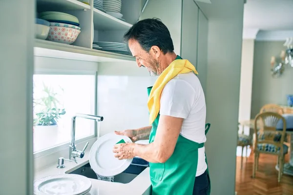 中年男子满脸胡须 高高兴兴地在家里洗碗 — 图库照片