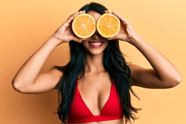 Mulher Hispânica Bonita Usando Biquíni Segurando Laranja Nos Olhos Sorrindo — Fotografia de Stock