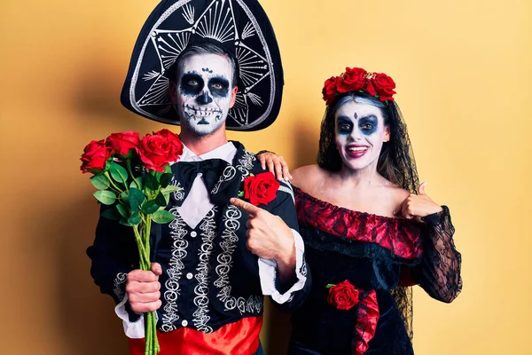 若いですカップル身に着けていますメキシコの日のザ死んだ衣装保持バラを指差す指に一人の自己笑顔幸せと誇り — ストック写真
