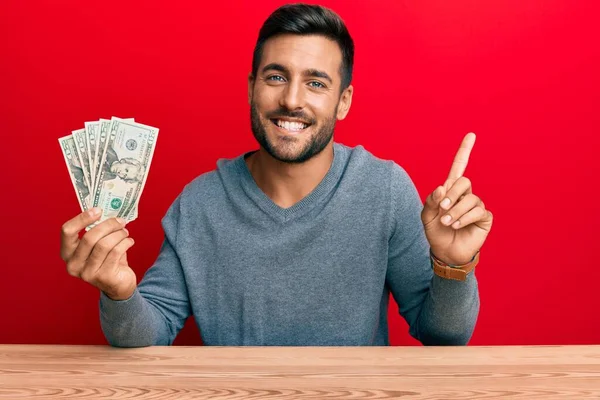 Красивий Іспаномовний Чоловік Тримає Доларів Банкноти Посміхаючись Щасливим Вказуючи Рукою — стокове фото