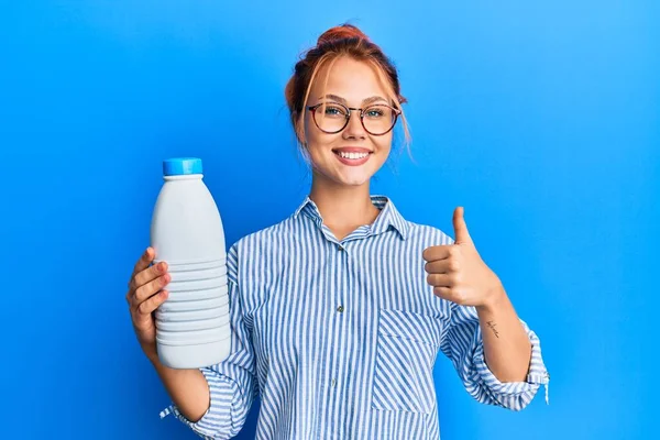 Молода Руда Жінка Тримає Літрову Пляшку Молока Посміхаючись Щасливим Позитивним — стокове фото