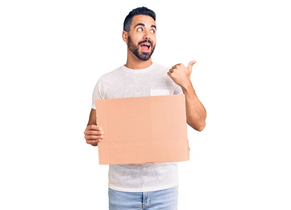 Mladý Hispánec Drží Banner Karton Ukazující Palec Nahoru Stranu Usmívá — Stock fotografie