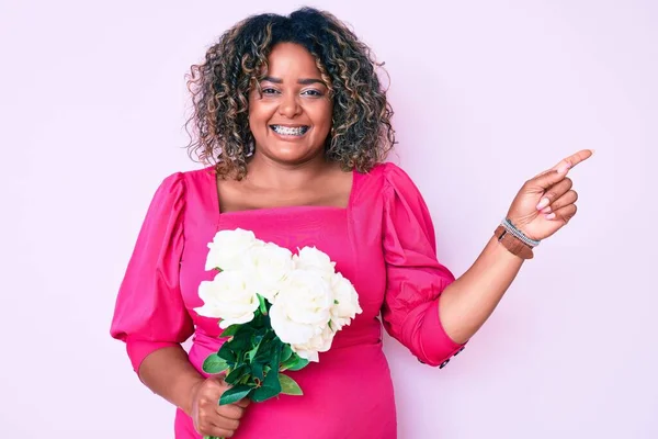 Jovem Afro Americana Size Mulher Segurando Flores Sorrindo Feliz Apontando — Fotografia de Stock