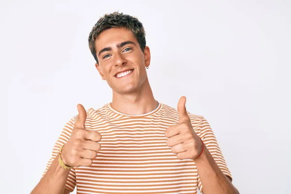 年轻英俊的男子穿着休闲装 成功的标志着用手做了一个积极的手势 竖起大拇指 微笑着 快乐地 快乐的表达和胜利的姿态 — 图库照片
