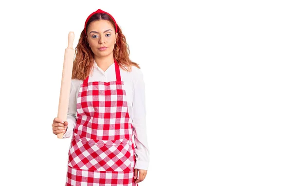 Mujer Latina Joven Usando Delantal Sosteniendo Actitud Pensamiento Amasadora Expresión — Foto de Stock