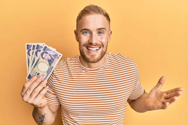 Joven Hombre Caucásico Sosteniendo Billetes Yen Japoneses Celebrando Logro Con —  Fotos de Stock