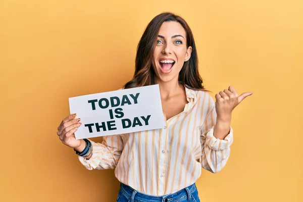 Joven Morena Sosteniendo Hoy Día Señalando Pulgar Hacia Lado Sonriendo — Foto de Stock