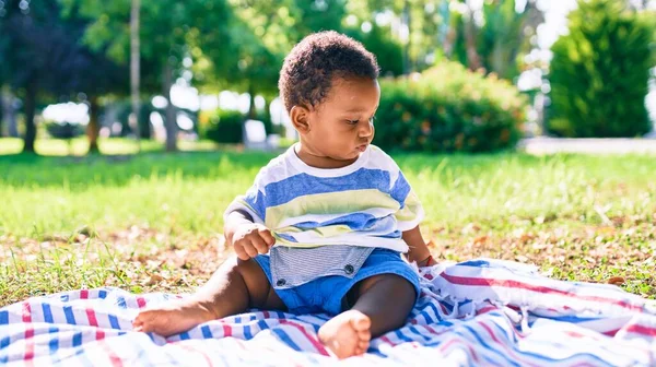 公園で草の上に座っている愛らしいアフリカ系アメリカ人の幼児 — ストック写真