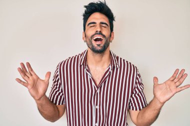 Yakışıklı, sakallı, sıradan kıyafetler giyen, çılgın ve başarıyı kutlayan kolları havada ve gözleri kapalı heyecanlı bir adam. Kazanan konsept 