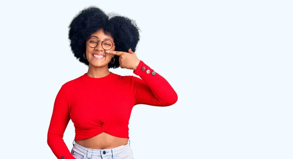 Młoda Afroamerykanka Luźnych Ciuchach Okularach Wskazująca Palcem Twarz Nos Uśmiechnięta — Zdjęcie stockowe