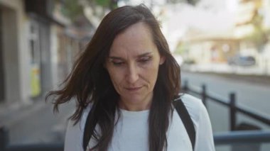 Bir şehir caddesinde sırt çantasıyla gülümseyen genç İspanyol kadın; mutluluk iyimserliği sevinç.