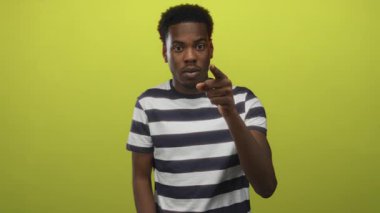 Stüdyoda, ciddi bakışları olan çizgili tişört giyen genç adam; ciddiyet iddiası yoğunluğu.