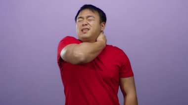 Mor arka planda kırmızı gömlekli adam muhtemelen boyun ağrısından ya da gözleri kapalı ve elleri boyunda gerilimden rahatsız olur..