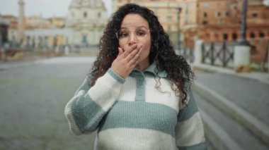 Roma harabelerinde duygularını ifade eden kadın, arka planda gündüz vakti antik mimariyle birlikte caddeyi yıkıyor..