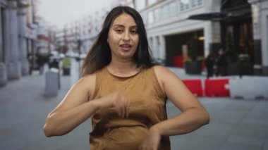 Avuç içleri açık ve şehir sokaklarında çıplak omuzları olan, avuç içlerini gösteren ve başını hafifçe çeviren bir kadın, seçim belirsizliği..