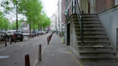 Bokeh etkisine sahip bir açık şehir ortamında Avrupa mimarisinin yer aldığı bulanık sokak manzarası sakin bir kentsel atmosferi vurguluyor.