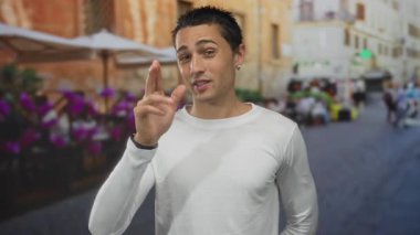 Tuğla binalar ve canlı çiçeklerle dolu teras kafesinde gülümseyen genç İspanyol adam hareketli restoran atmosferine sıcaklık katıyor..