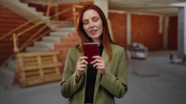 İnşaat alanında elinde Norveç pasaportu olan bir kadın, kimlik ve seyahat belgelerini kendinden emin bir ifadeyle gösteriyor..