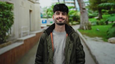 Genç bir adam sokak gösteriş cazibesine ve karizmasına sıradan bir ortamda jest yapıyor.