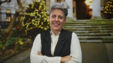 Şehir caddesinde kollarını kavuşturmuş gülümseyen bir kadın inşa edilerek festival ışıklarının önünde yürüyor..