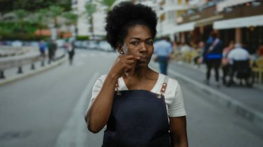 Yoğun bir caddede, bulanık kafeleri ve şehir geçmişi olan, iletişim ve nişan işlemleri yapan önlüklü bir kadın..