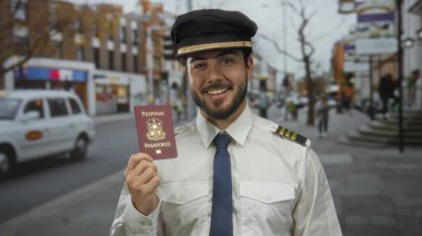 Filipin pasaportlu genç pilot şehrin arka planında gülümsüyor, seyahat hazırlığı ve uluslararası seyahat heyecanı sergiliyor..