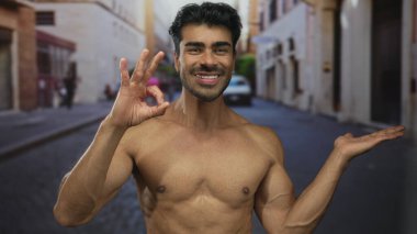 Çıplak göğsü olan gömleksiz bir adam kaldırım taşı caddesinde güneş ışığı altında gülümserken 