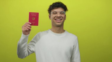 Yeşil stüdyoda yeşil zemine karşı elini kaldırmış Alman pasaportu taşıyan adam, gururlu..