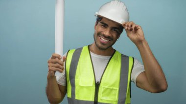 Yelek giyen İspanyol mühendis mavi stüdyoda el yapımı ve eğimli planlar taşıyordu. Güven gururu profesyonelliği..