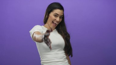 Stüdyoda elini uzatmış, mor arka planda el sıkışan bir kadın var..