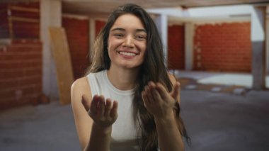 Kadın el ele öpüşür, dudaklar dudaklara tuğla duvarlar ve tahta kiriş kolonlar ile tamamlanmamış bina içinde; şefkat.