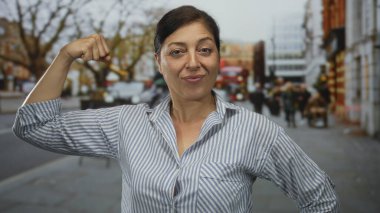 Bulanık yayalar ve araçlar arasında çıplak kollarını esneten orta yaşlı İspanyol kadın..