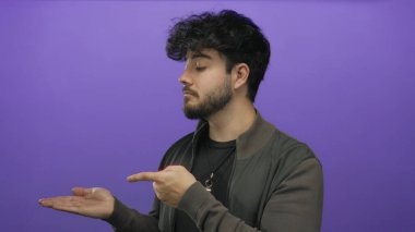 Avuç içinin açık olduğunu gösteren sakallı, koyu renk ceketli, siyah ceketli, meraklı ya da sunum yapan genç bir İspanyol..