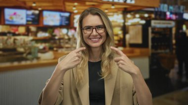 Lokantada gülümseyen ve kendini gösteren bir kadın. Sıcak, davetkar bir atmosferi ve canlı bir ışıklandırması var. Neşeli bir anı yakalıyor..