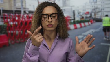 Kırmızı bariyerler ve yol konileri olan cadde inşaat alanında kadınlar parmaklarına güveniyor; konsantrasyon.