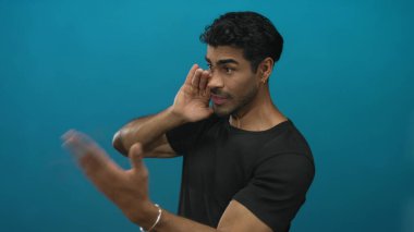 Erkekler el pençe divan durur, başını öne eğip mavi stüdyoda şaşı kalır; aktif dinleme merakı.