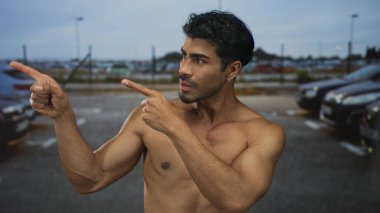 Çıplak göğsü olan adam, sokak otoparkında yan yan bakarken iki parmağını da bulanık arabalara doğrultuyor. Kendinden şüphe ediyor..