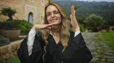 Üniforma giyen genç sarışın kadın yargıç eski kasaba sokaklarında pozlar veriyor. Çerçeveli yüzler ve eller..