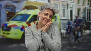 Kadın yüzüne yakın el kaldırır ve şehir caddesinde bulanık bisikletçilerle neşeyle gülümser; saf neşe.