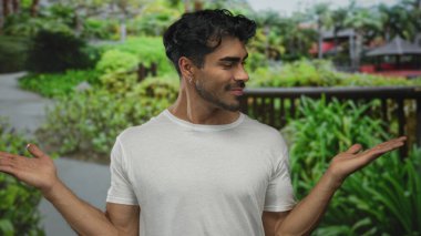 Avuç içi açık duran ve ormandaki ahşap çitlerin yanında gülen yeşil yapraklı bir adam. Güven güven..