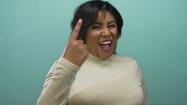 İspanyol kadın, yeşil arka planda gülümseyen parmaklarını sayıyor, olumlu ifadeler ve jestler sergiliyor, güven ve neşe saçıyor..