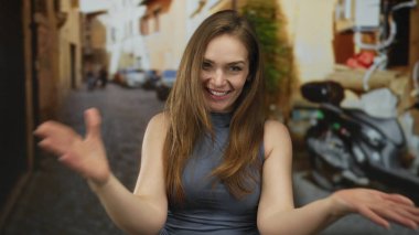 Genç Kafkas kadın neşeli bir şekilde el uzattı buraya bir kaldırım taşı sokakta jest; sıcak dostça karşılama daveti.