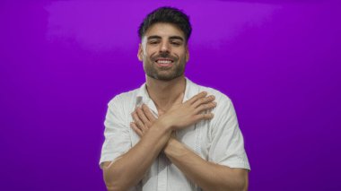 Adam stüdyoda açık bir jest ile kameraya çıplak kollarını uzatır parlak mor bir arka plana karşı ve gülümseme; şefkat rahatlık.