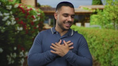 İki eli mavi polo gömlekli, yeşil çitlerle kaplı ve bulanık ev girişi olan bir sokakta sandık tutan adam, minnettarlık samimiyeti samimiyeti sıcaklığı.