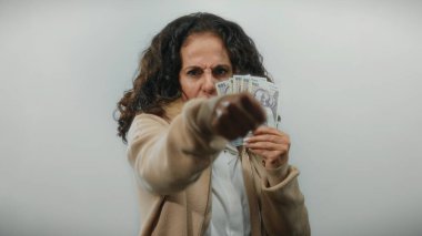 Kadın, beyaz bir zemin üzerinde Romanya banknotları tutarken kameraya öfkeyle yumruk atıyor ve hayal kırıklığını dile getiriyor.